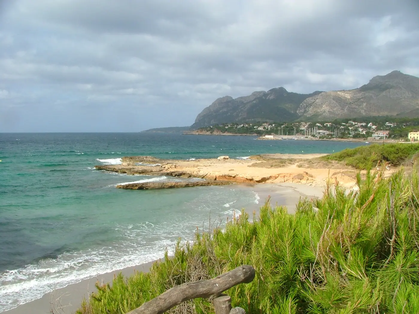 Vue large de la baie de Manresa/Bonaire près d'Alcúdia, eau turquoise et Serra de Tramuntana en arrière-plan.