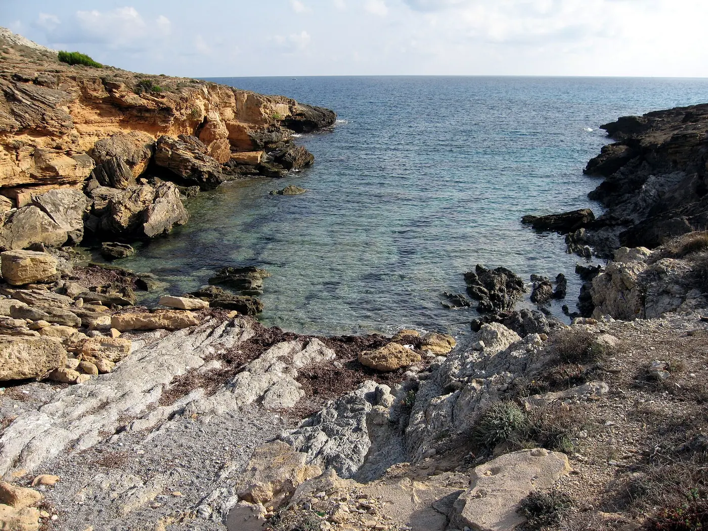 Piscine naturelle rocheuse de Cala Estreta, eau turquoise.