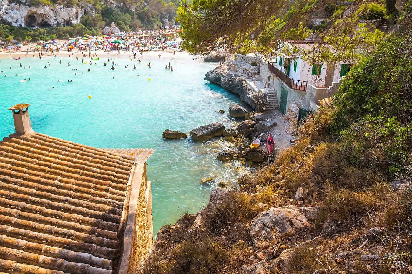 La plage et ses maisons de pêcheurs traditionnelles au bord de l'eau turquoise.