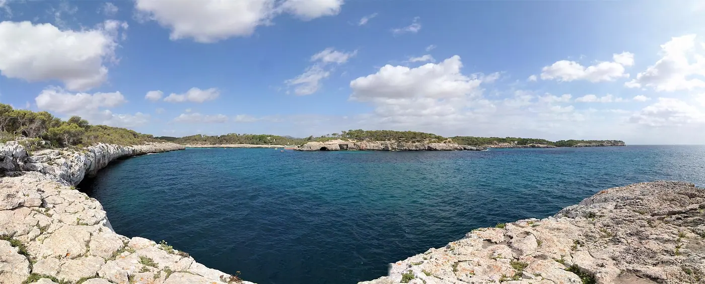 Panorama large sur la baie de Cala Mondragó et son littoral protégé.