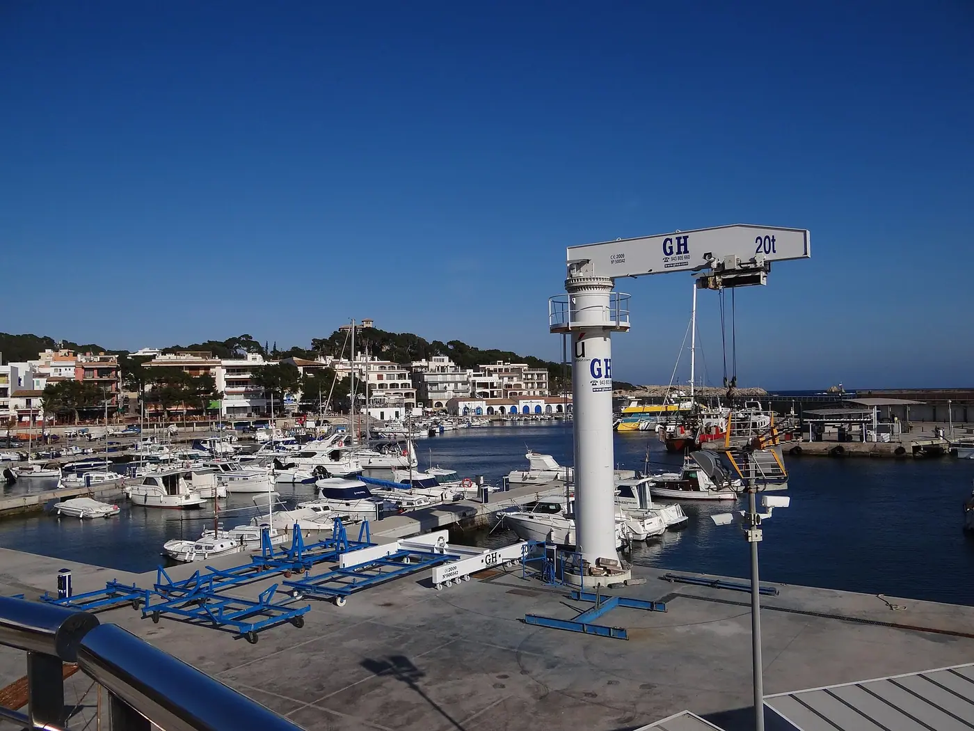 Marina animée de Cala Rajada sous un grand ciel bleu.