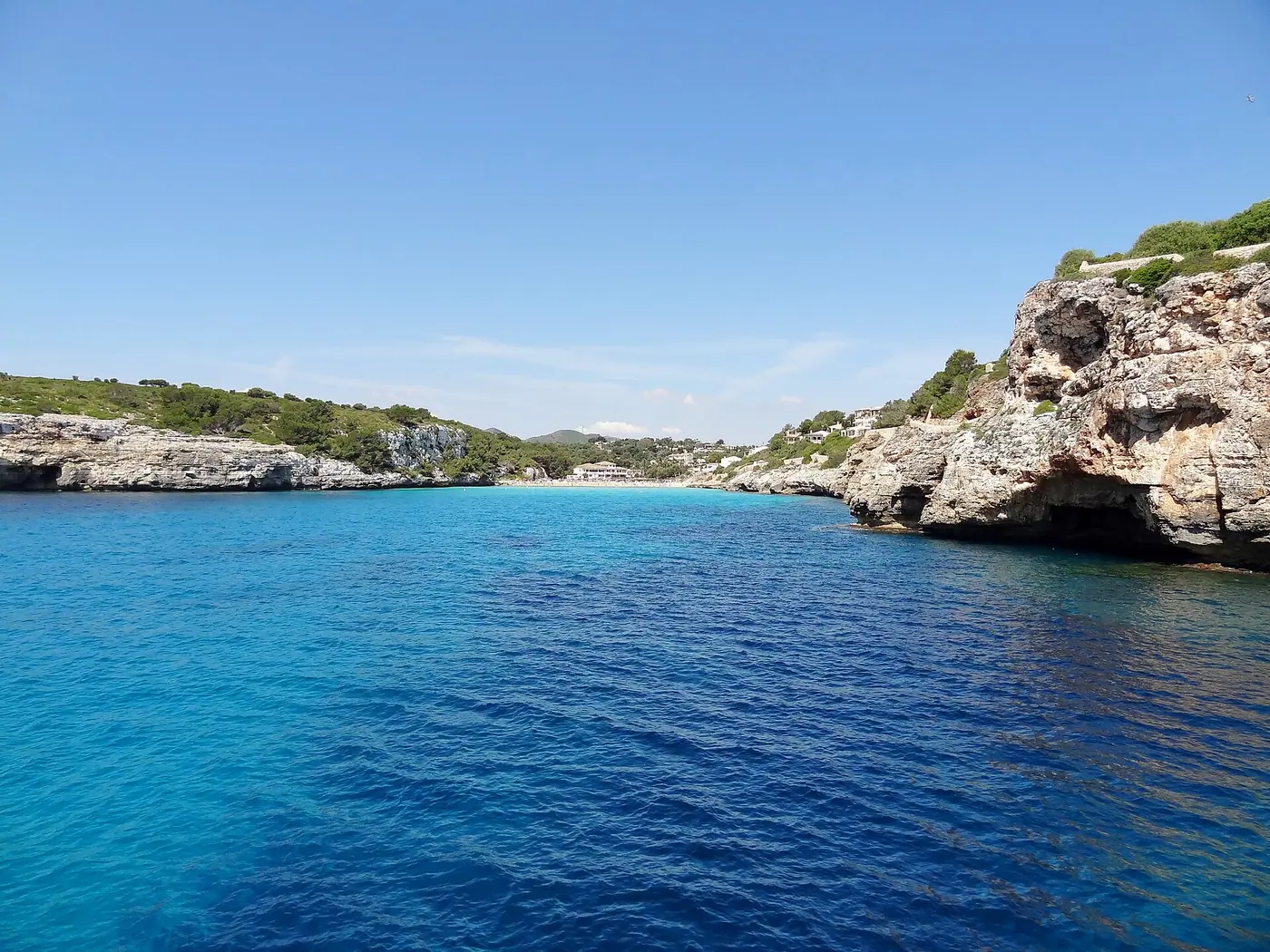 Entrée rocheuse de la crique aux eaux turquoise profondes entre les falaises.