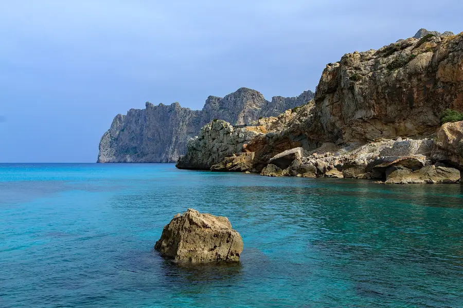 Cala Barques: rocher affleurant dans une eau turquoise cristalline.