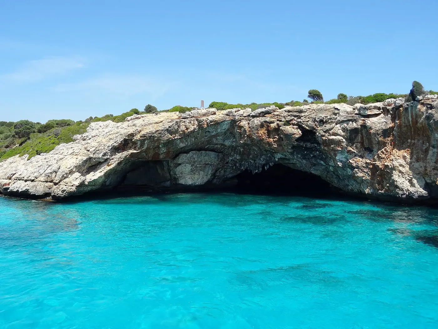 Arche naturelle et grotte marine aux eaux cristallines à Cala Varques.