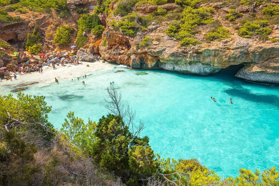 Vue plongeante sur le Caló des Moro, crique emblématique entre deux falaises.