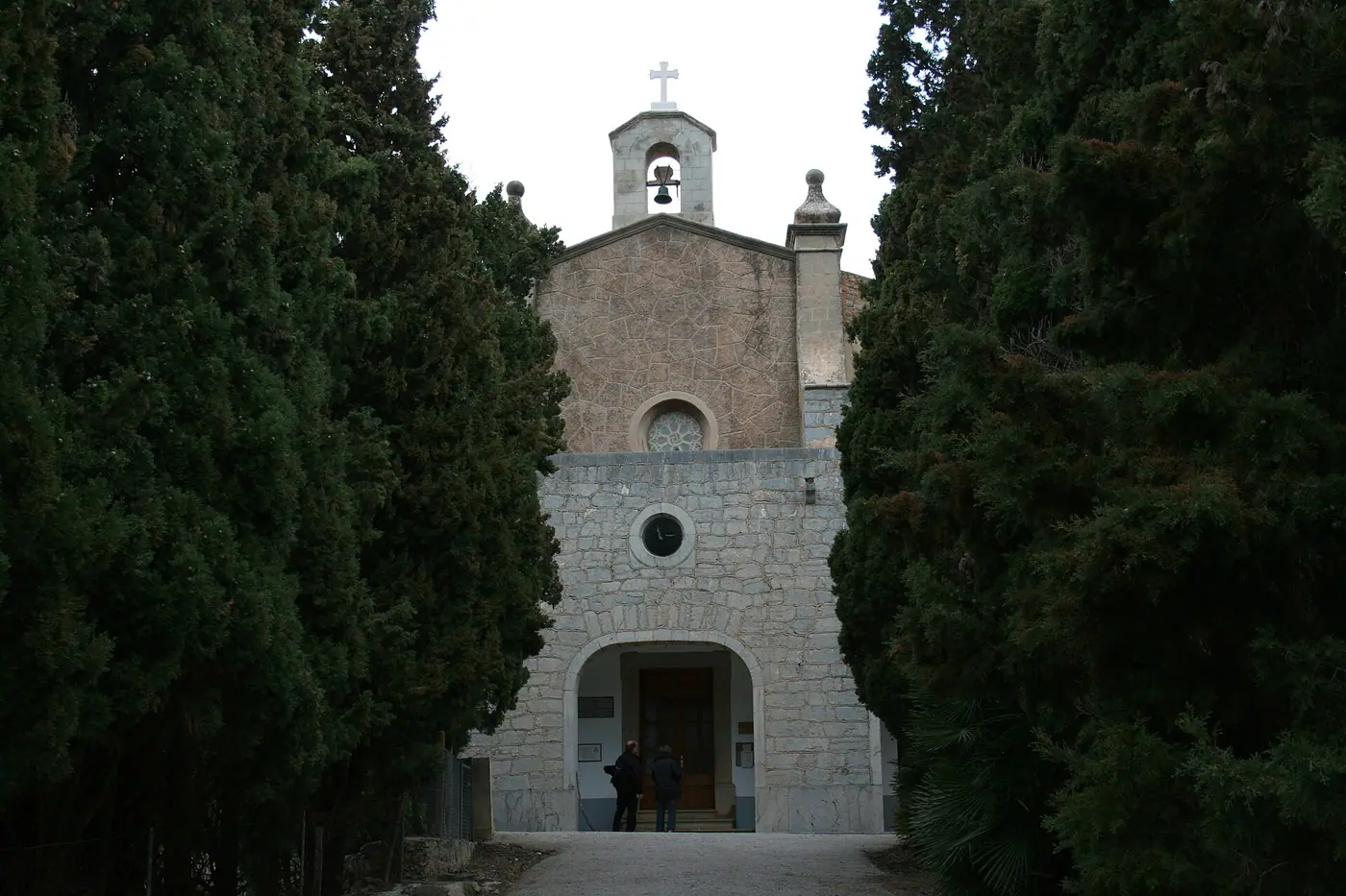 La façade de l'Ermita de Betlem encadrée par de hauts cyprès.