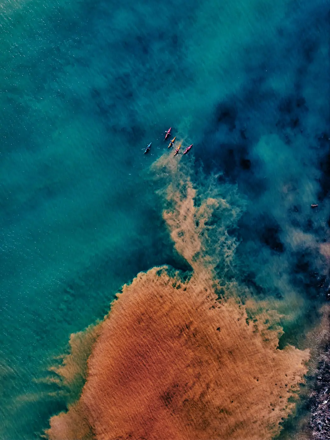 Kayaks pagayant dans une eau turquoise