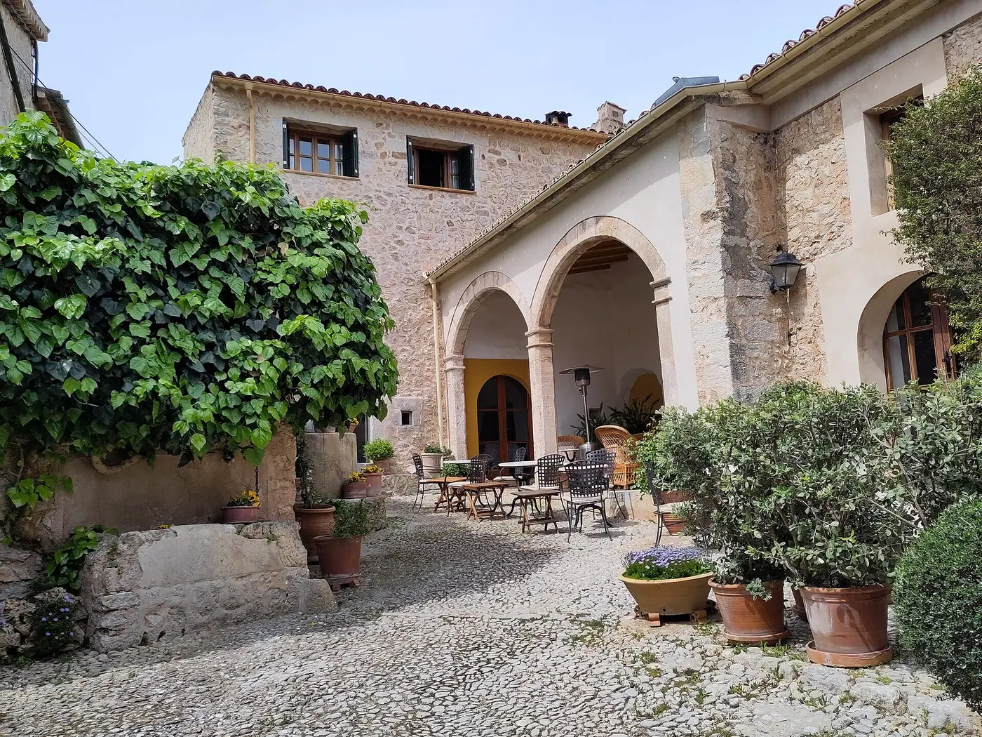 Terrasse en pierre typique du hameau d'Orient, avec arcades et poteries traditionnelles.