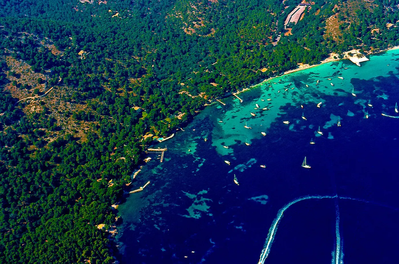 Vue aérienne de la crique de Formentor, eau turquoise et bateaux au mouillage.