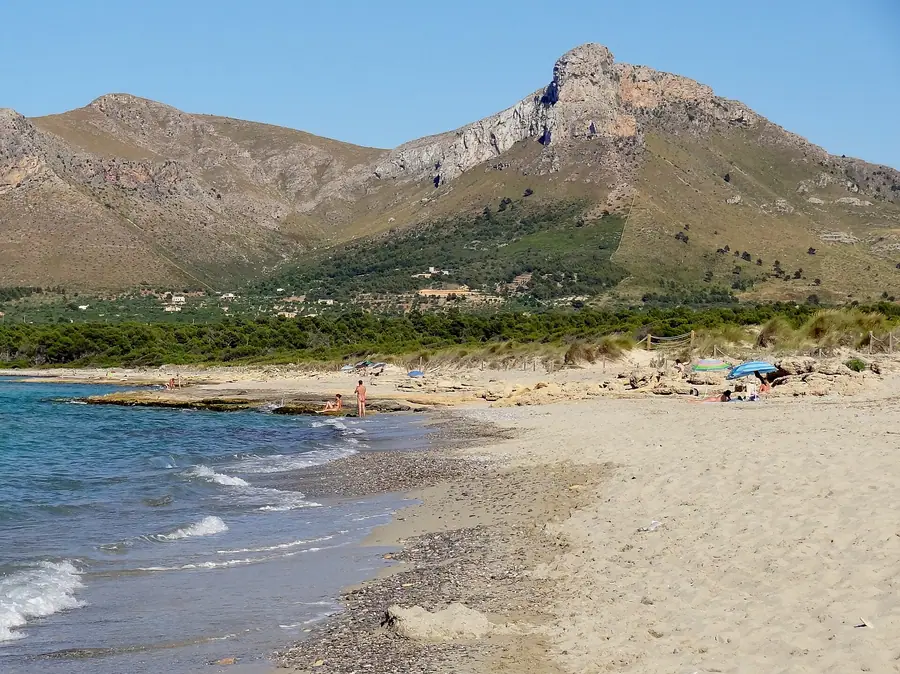 Plage sauvage de Sa Canova, dunes et montagnes en arrière-plan.