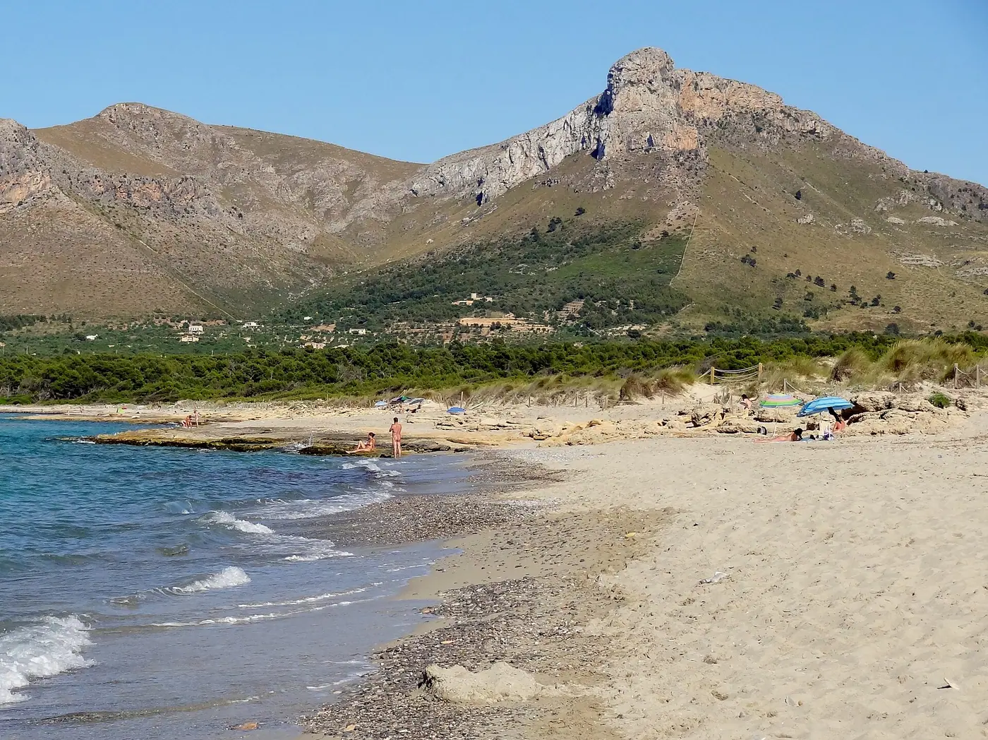 Plage sauvage de Sa Canova, dunes et montagnes en arrière-plan.