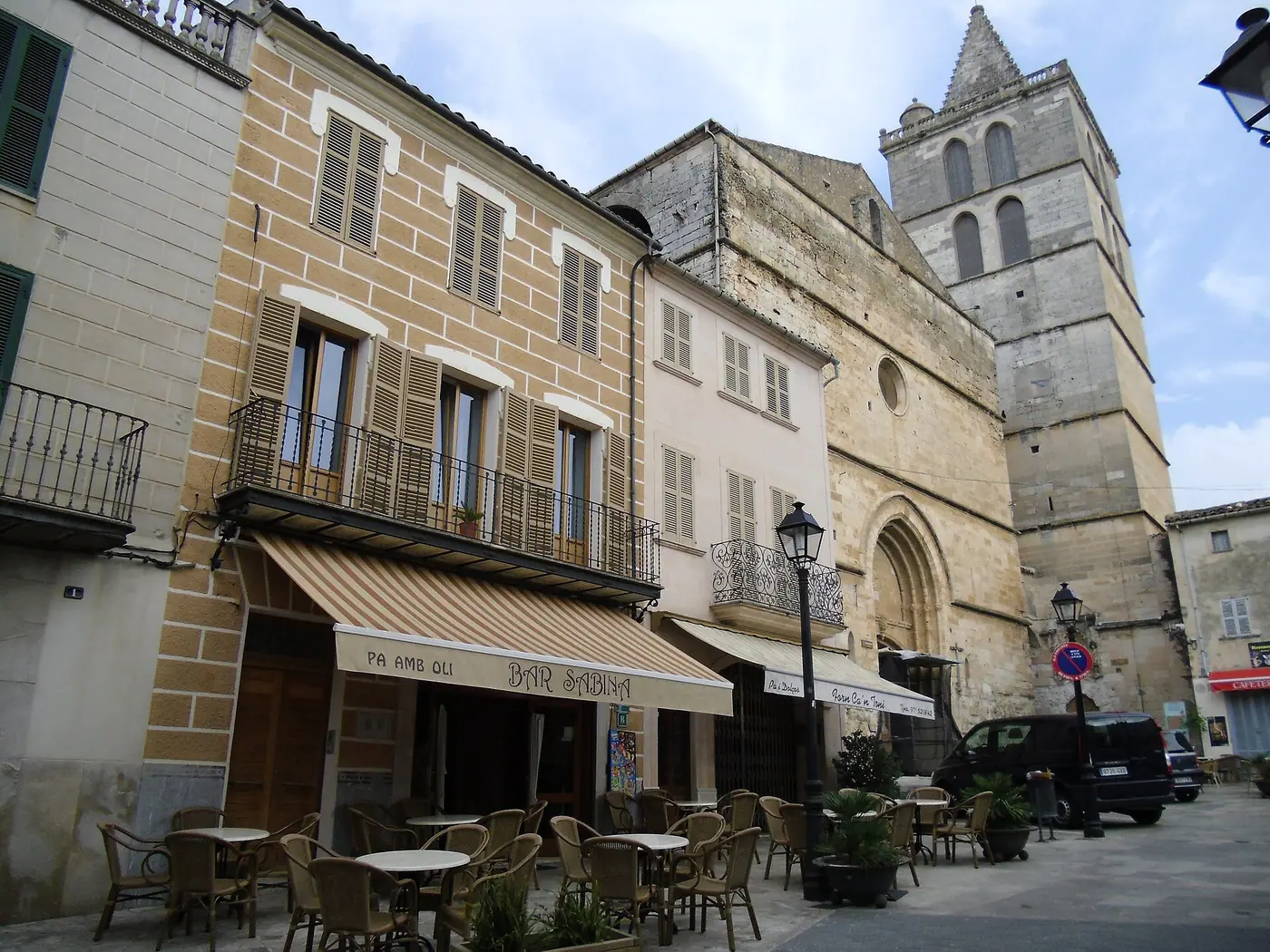 Rue animée de Sineu avec le clocher de l'église