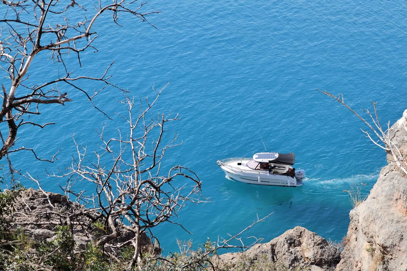 Bateau semi-rigide longeant des falaises méditerranéennes